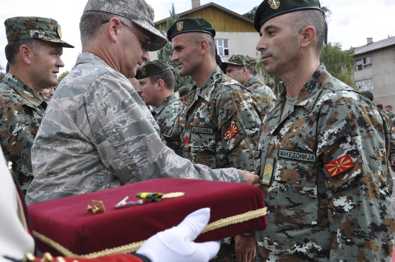 U.S. Air Force Maj. Gen. Steven Cray, the adjutant general of the Vermont National Guard, pins a medal on one of 79 soldiers from the army of Macedonia